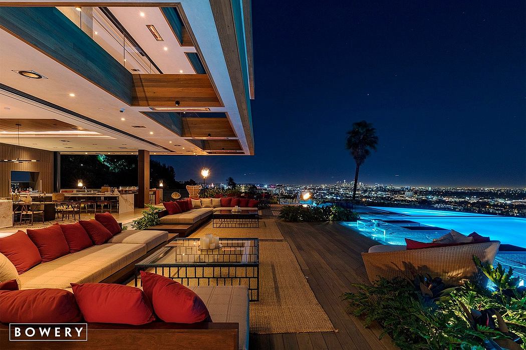 Stunning modern outdoor deck with pool, city skyline view, and warm lighting.