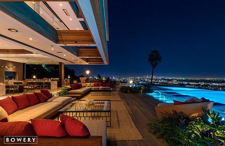 Stunning modern outdoor deck with pool, city skyline view, and warm lighting.