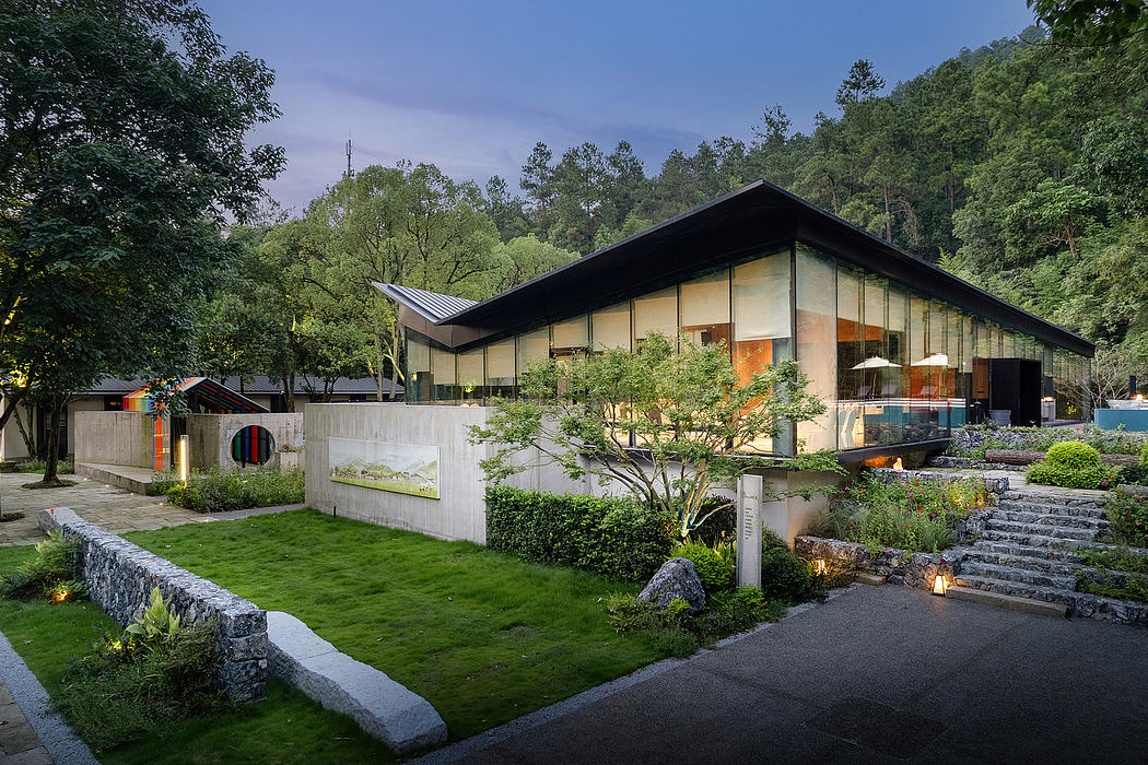Contemporary mountain lodge with glass walls, landscaped gardens, and stone pathways.