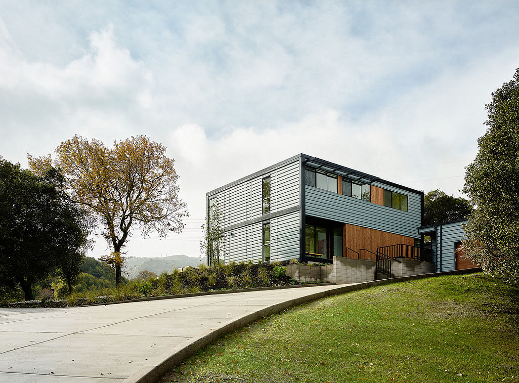 A modern, multi-story home with a combination of wood and metal siding, nestled in a lush landscape.