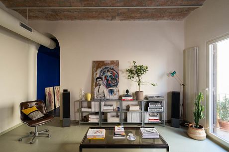 Exposed brick ceiling, modern shelving, eclectic decor in this cozy living space.