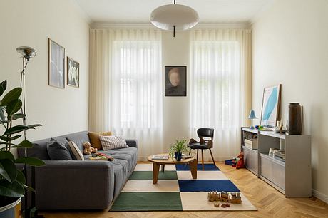 A cozy and well-designed living room with modern furniture, artwork, and natural lighting.