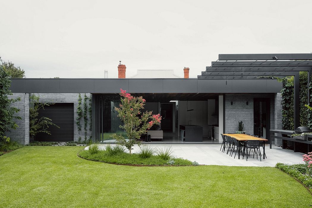 Contemporary home with sleek black exterior, open-plan layout, and lush landscaping.