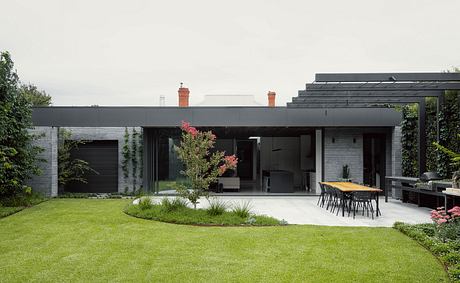 Contemporary home with sleek black exterior, open-plan layout, and lush landscaping.