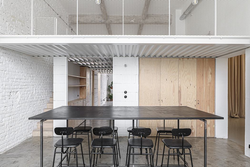 Large modern workspace with concrete ceiling, metallic shelves, and wooden panels.