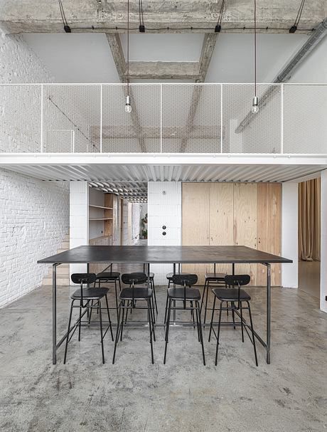 Large modern workspace with concrete ceiling, metallic shelves, and wooden panels.