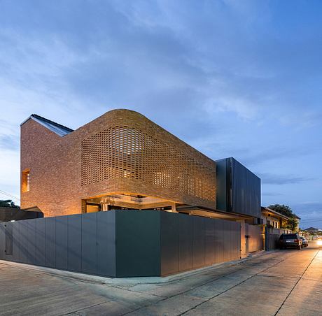 Striking brick architecture with intricate perforated facade, black exterior panels.