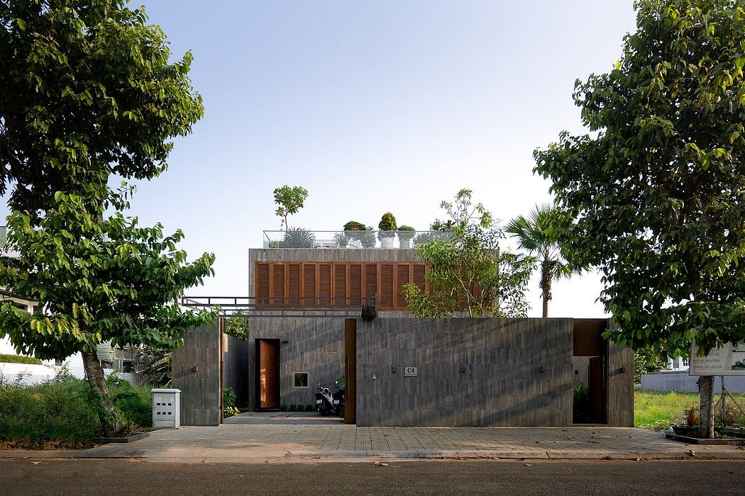 Modern residential building with concrete exterior, wooden screens, and rooftop garden.