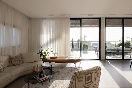 Spacious living room with large windows, modern furniture, and minimalist decor.