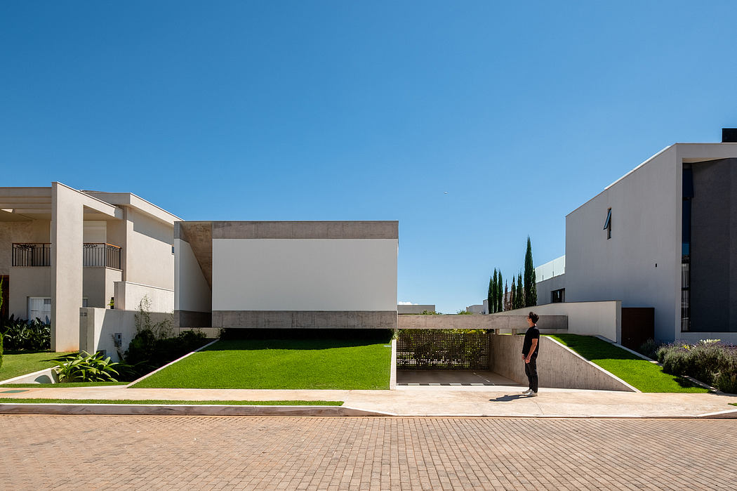 A modern, minimalist exterior with clean lines, geometric forms, and lush greenery.
