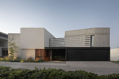 Sleek, modern architecture with geometric patterns, wood accents, and landscaped entryway.