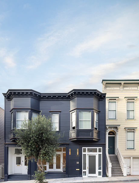 Two-story Victorian-style building with decorative facade and bay windows.