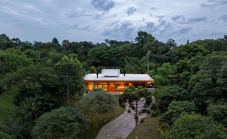 Modern, single-story home with orange exterior surrounded by lush, verdant foliage.