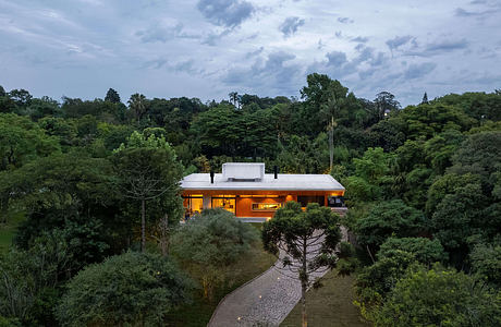 Modern, single-story home with orange exterior surrounded by lush, verdant foliage.