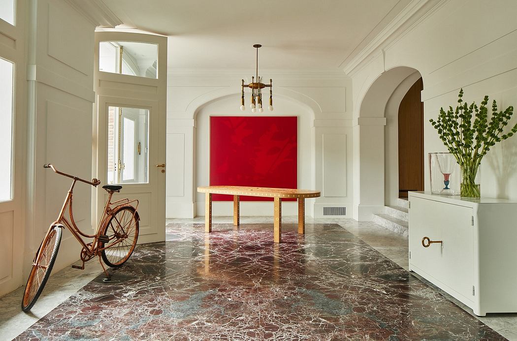 Elegant foyer with arched doorways, marble floors, and a vibrant red art piece.