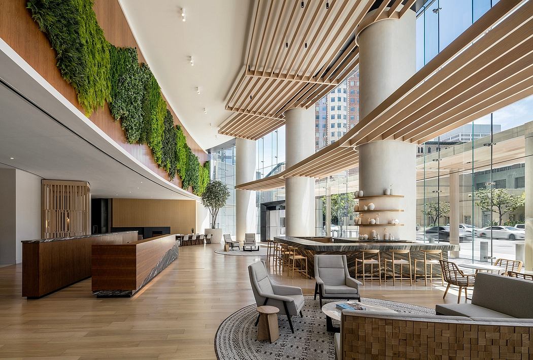Spacious lobby with wood-paneled ceilings, greenery walls, and modern furnishings.