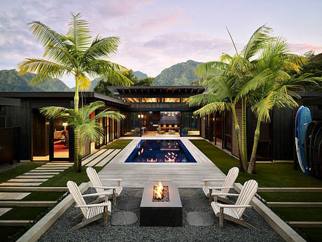 Tropical retreat with modern architecture, pool, fire pit, and lush palm trees.