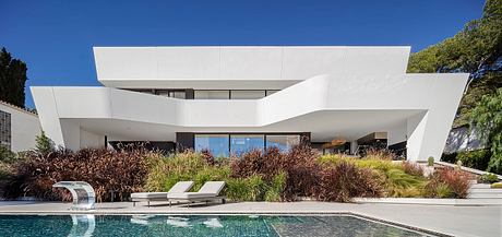 Sleek, modern architectural design with clean lines, spacious pool area, and lush landscaping.