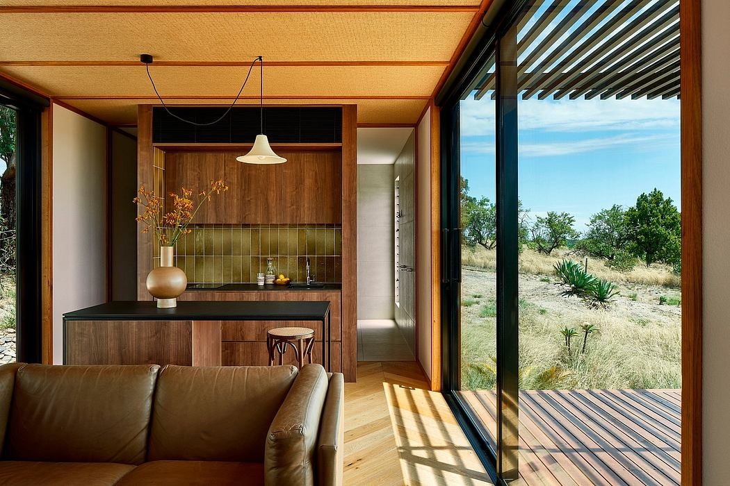 Warm, rustic interior with wooden finishes, open glass walls, and desert landscape view.