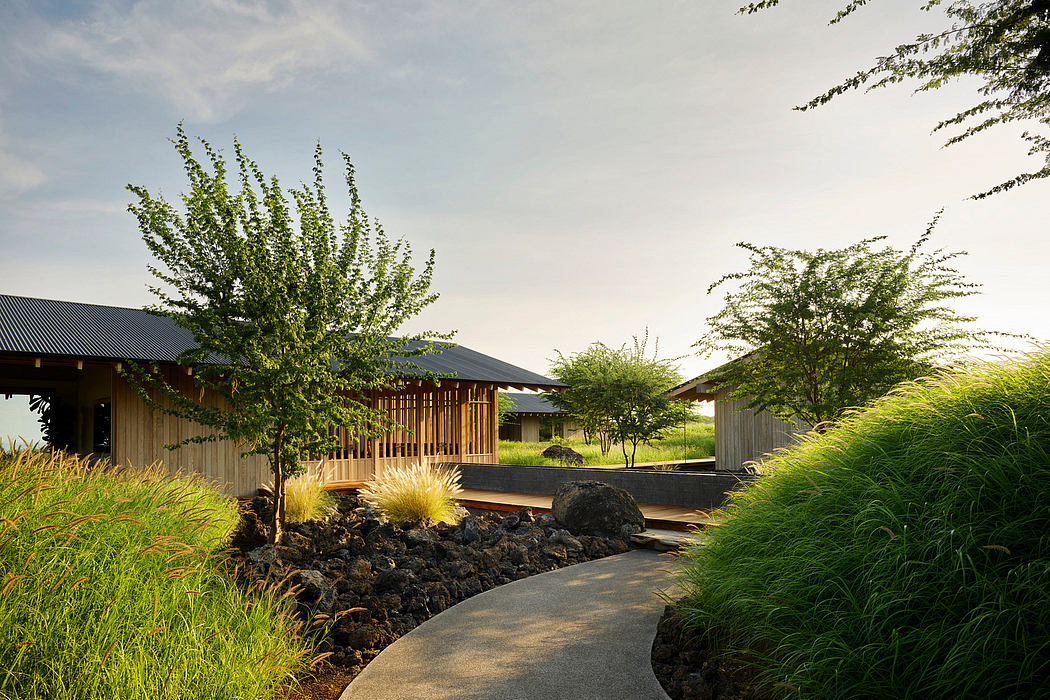 Serene Japanese-inspired garden pathway leading to modern wooden structures with lush greenery.