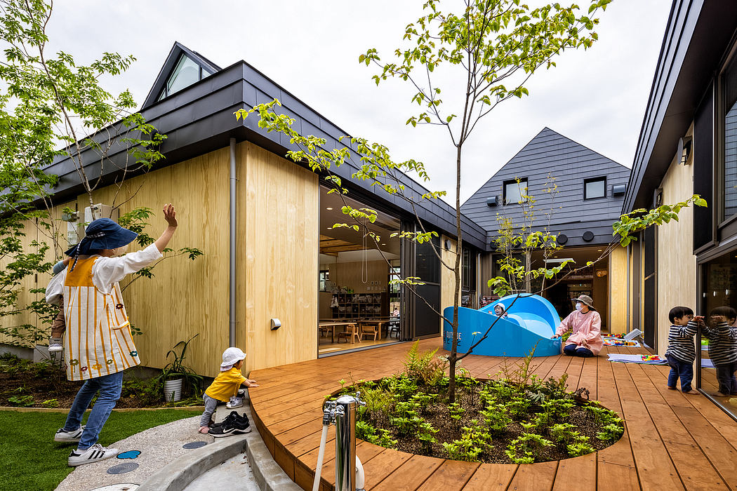 A modern outdoor play area with wooden structures, greenery, and a tent for children.