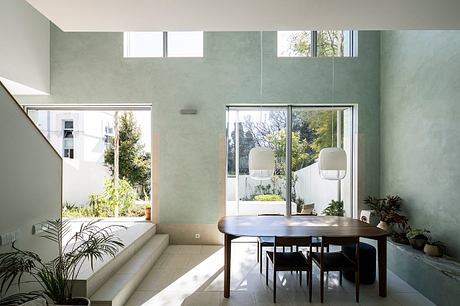 Spacious open-plan dining area with tall windows, natural light, and minimalist decor.