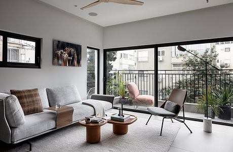 Cozy modern living room with large windows, neutral color palette, and contemporary furniture.