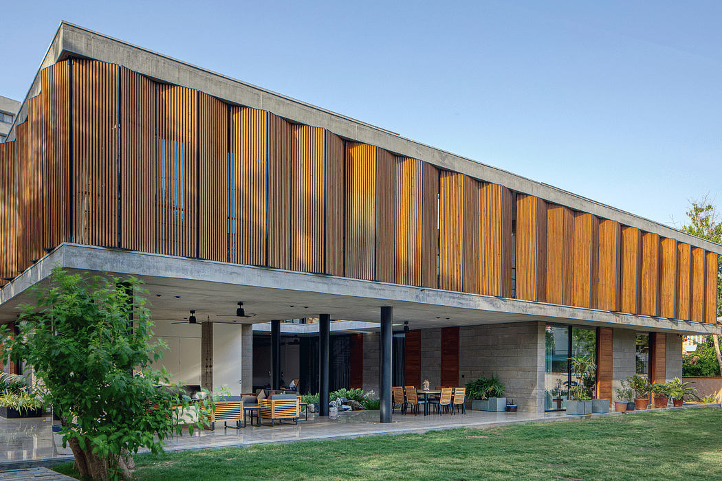 Expansive wooden facade, covered outdoor seating, and natural landscaping elements.