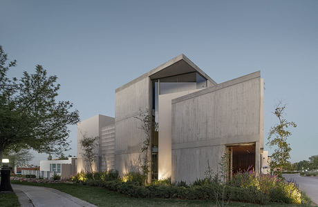 Striking modern concrete and glass structure with landscaped gardens.