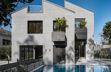 Sleek, modern home with geometric shapes, concrete exterior, and a reflection pool.