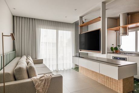 Cozy living room with neutral tones, minimalist TV console, and large window for natural light.