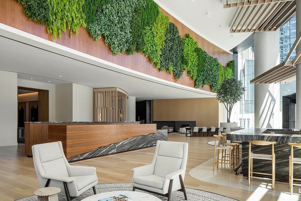 Expansive lobby with lush green wall, wooden furnishings, and marble accents.