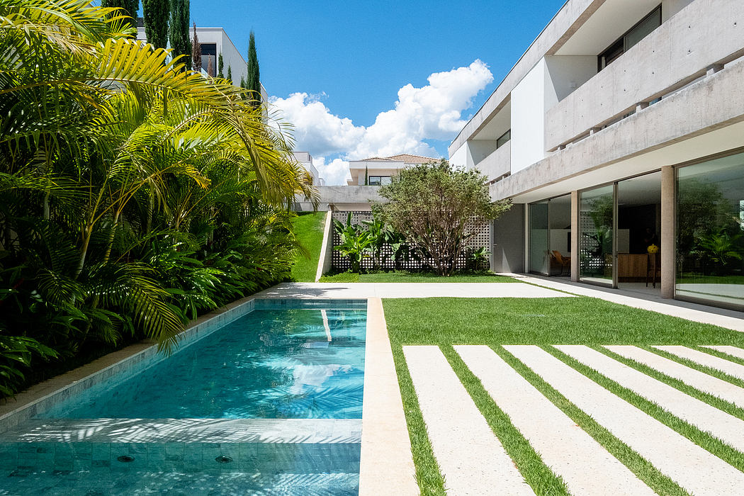 Sleek, modern architecture with a pool and lush tropical landscaping create a serene outdoor oasis.