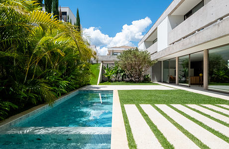 Sleek, modern architecture with a pool and lush tropical landscaping create a serene outdoor oasis.