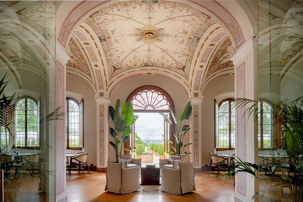 Ornate arched ceiling with intricate frescoes, overlooking a lush garden through large windows.