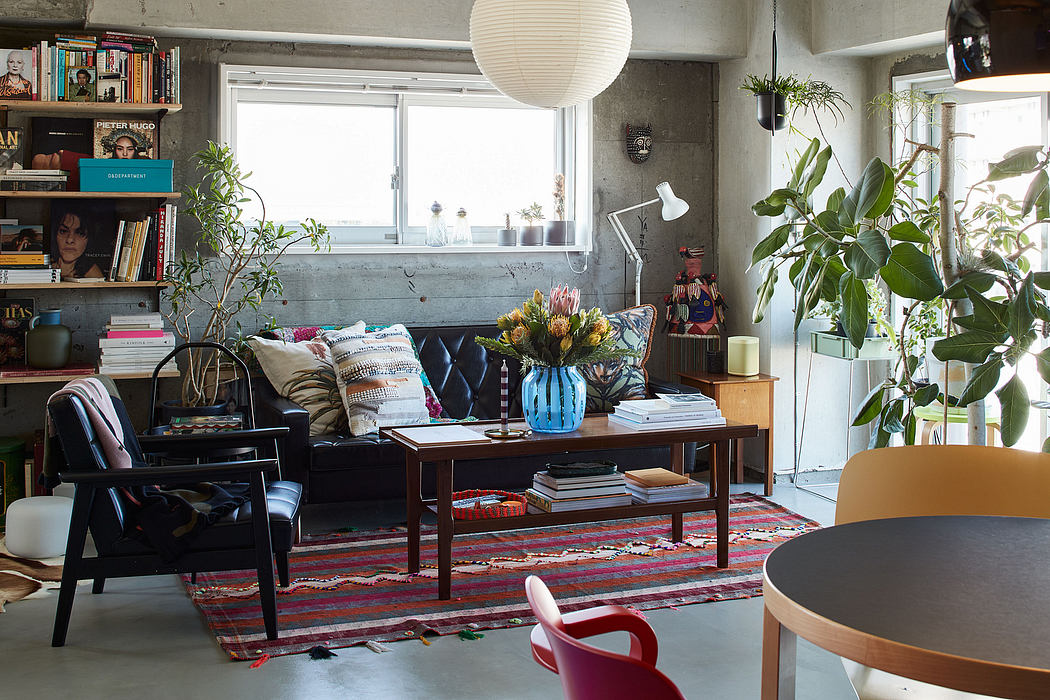 Cozy living room with textured concrete walls, leafy plants, and eclectic furnishings.