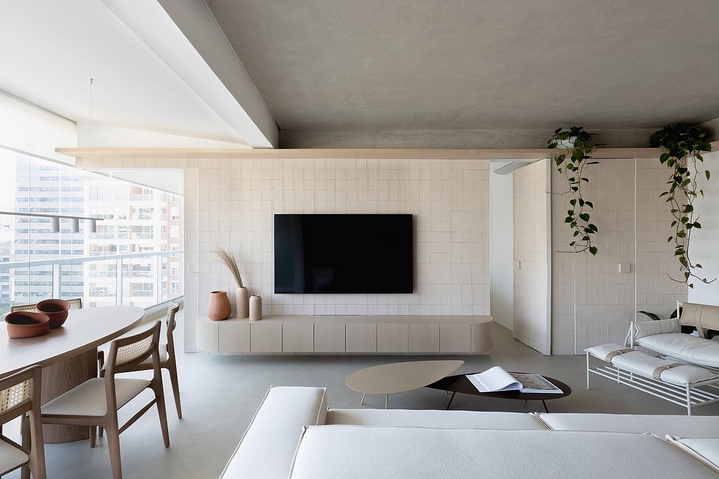 Modern open-concept living room with minimalist design, large TV, and abundant natural light.
