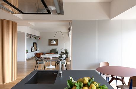 Modern open-concept apartment with wood accents, sleek kitchen island, and dining area.