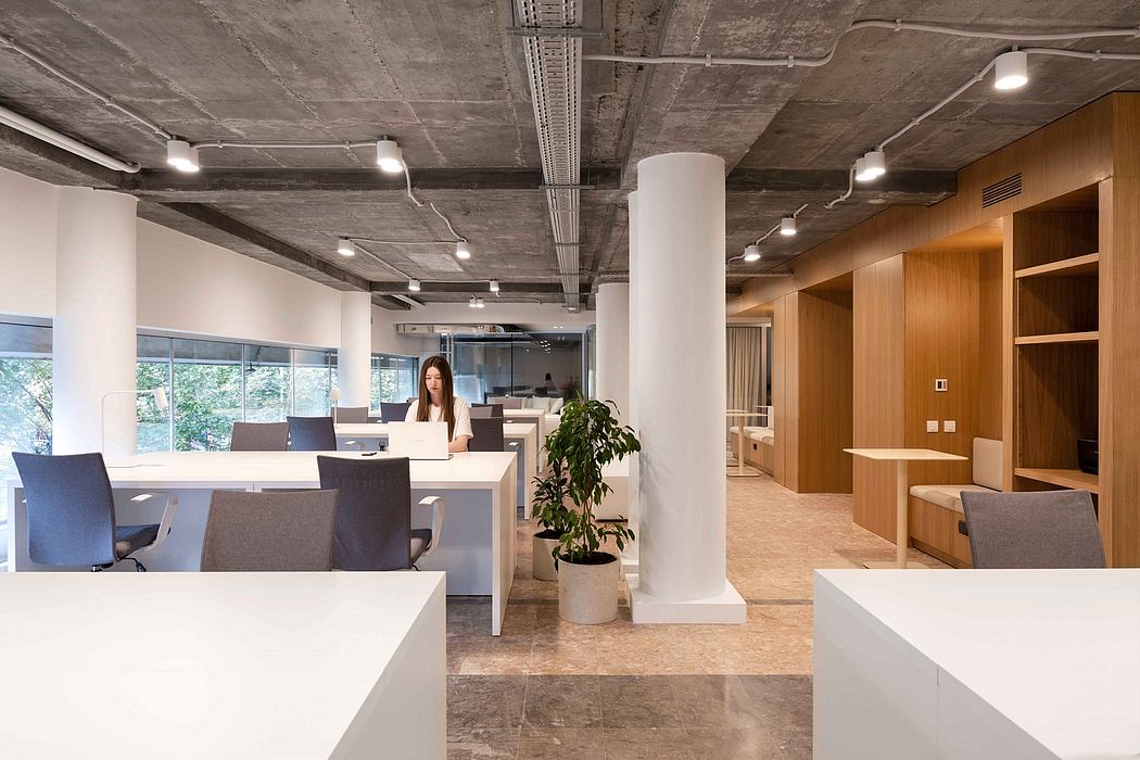 Spacious modern office with concrete ceiling, wooden accents, and workstations.