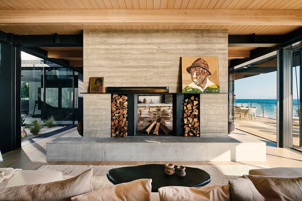 Modern, minimalist living space with concrete fireplace, wood storage, and artwork.