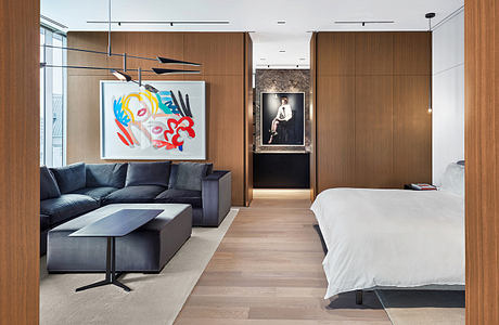 Modern open-plan living space with wooden paneling, contemporary artwork, and sleek furnishings.