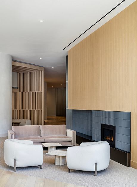Minimalist living room with wood-paneled walls, fireplace, and modern furnishings.