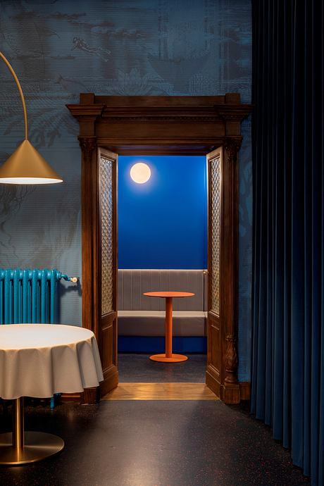 Ornate wooden doorway frames a serene moonlit view, accented by warm lighting and furniture.