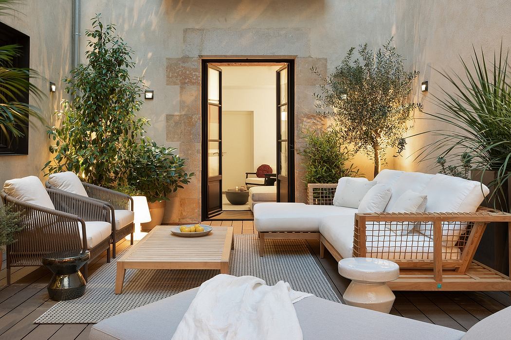 Cozy outdoor lounge area with wood furnishings, potted plants, and a view of a doorway.