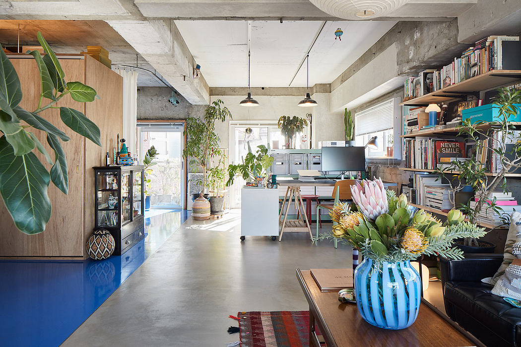 Eclectic home office with concrete walls, natural wood, and vibrant house plants.