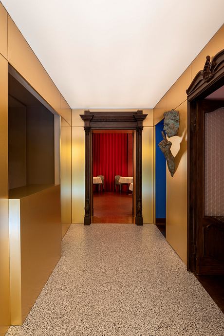 Elegant entryway with ornate wooden frame, red curtains, and terrazzo flooring.