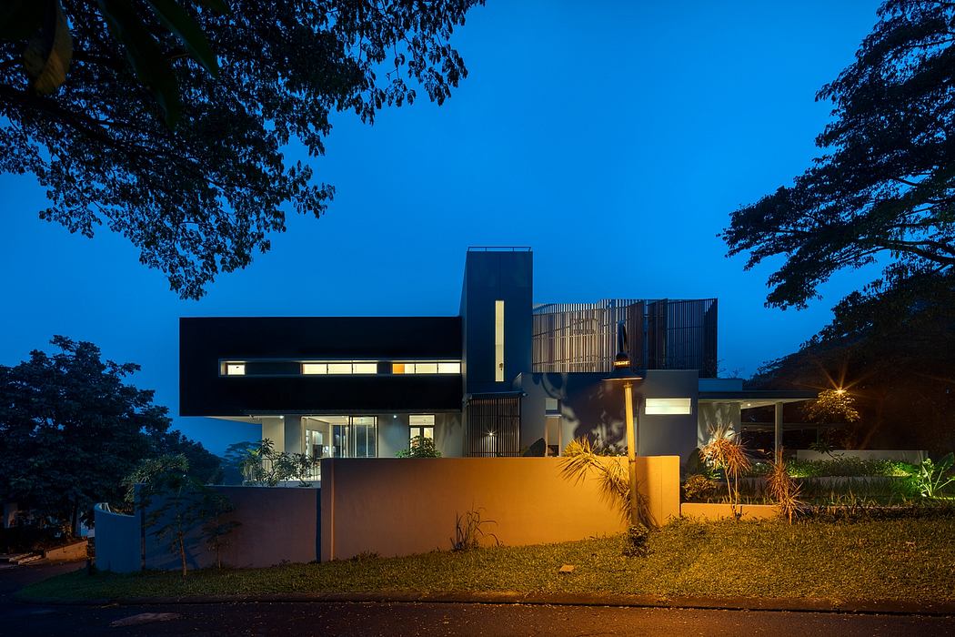 Striking modern home with dramatic exterior lighting and sleek architectural features.
