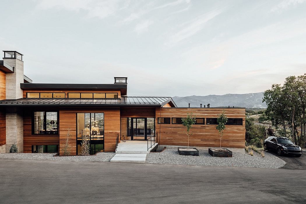 A modern, wooden-paneled mountain home with large windows and a balanced, sleek design.