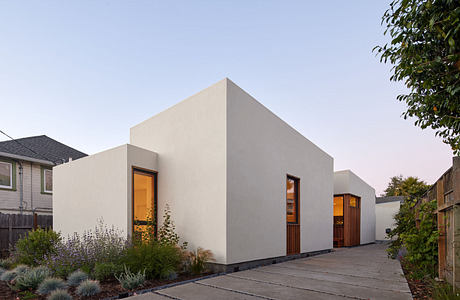 Modern, minimalist residential architecture featuring a striking geometric facade, wooden accents, and well-landscaped surroundings.