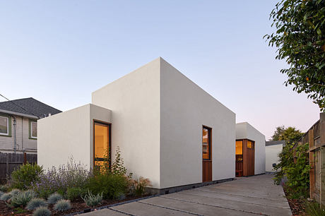 Modern, minimalist residential architecture featuring a striking geometric facade, wooden accents, and well-landscaped surroundings.